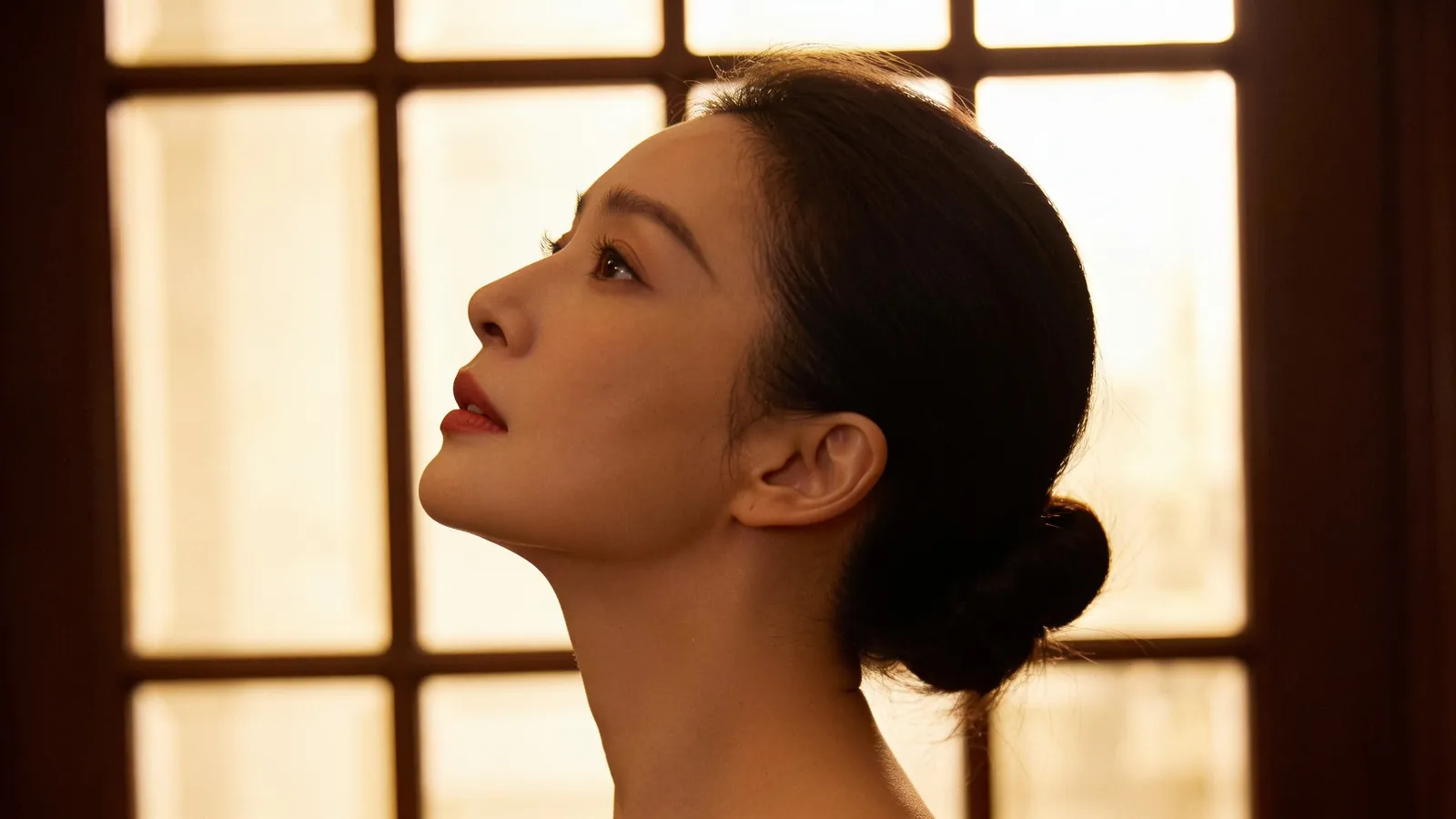 An East Asian woman in her 30s in side profile with chin lifted — illustrative image