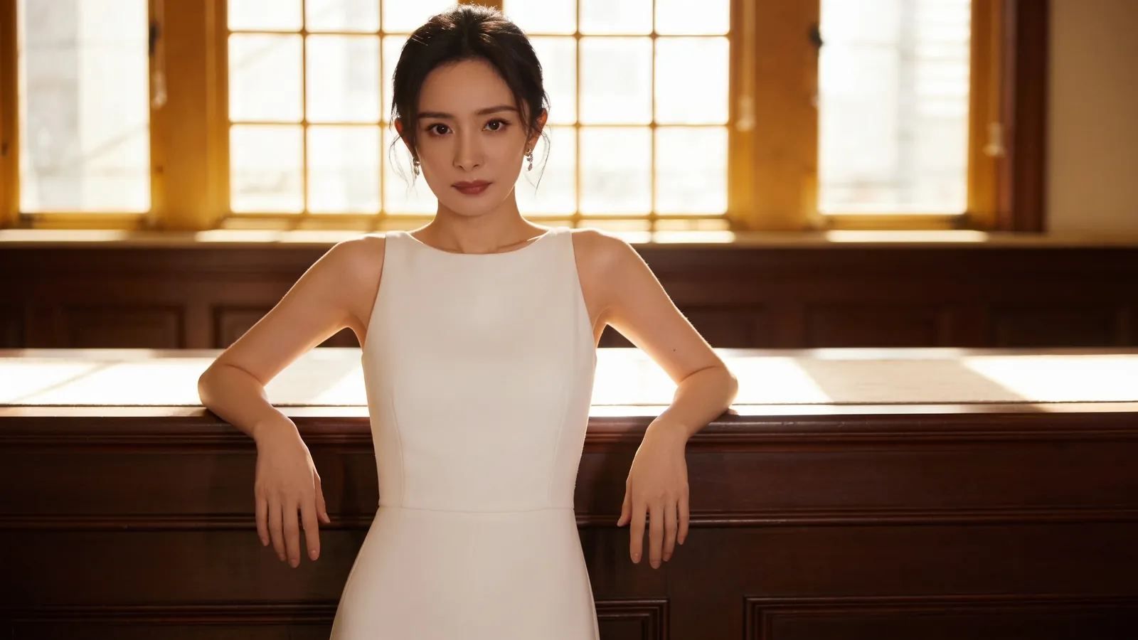 An East Asian woman in a white sleeveless dress with arms relaxed — illustrative image
